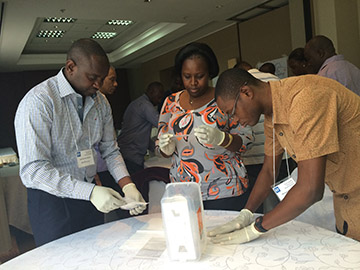Jean de Dieu Butura, Kamarazni Bakunda, and Mike Amakyi practice storing blood samples. 