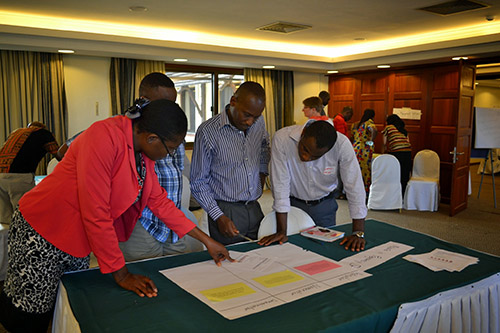 Participants from Nigeria, Uganda, and Malawi collaborate on interpreting malaria data.